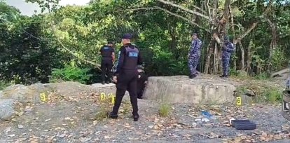Agentes de la Policía recolectan evidencia en el lugar donde fueron encontrados dos cuerpos en Jarabacoa