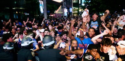 La policía intenta frenar el acceso de los fanáticos en las afueras del Madison Square Garden que proyectó en pantalla gigante el partido del sábado.