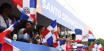 Las Reinas del Caribe ondean las banderas dominicanas durante la caravana de los medallistas.