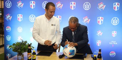 Fabián Suáre y José Francisco Deschamps firman un balón para concretar el acuerdo.