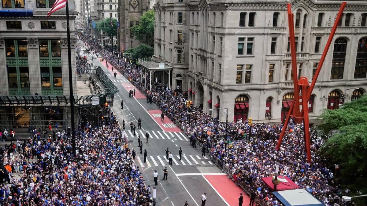 Multitudes llenan las aceras esperando el inicio del desfile de confeti para los Knicks de Nueva York, campeones de la NBA, en Broadway, en el
