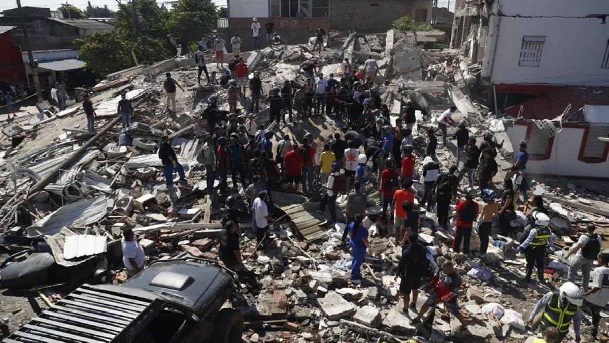 Personas observan los escombros de edificaciones colapsadas por el terremoto en Cali (Colombia).