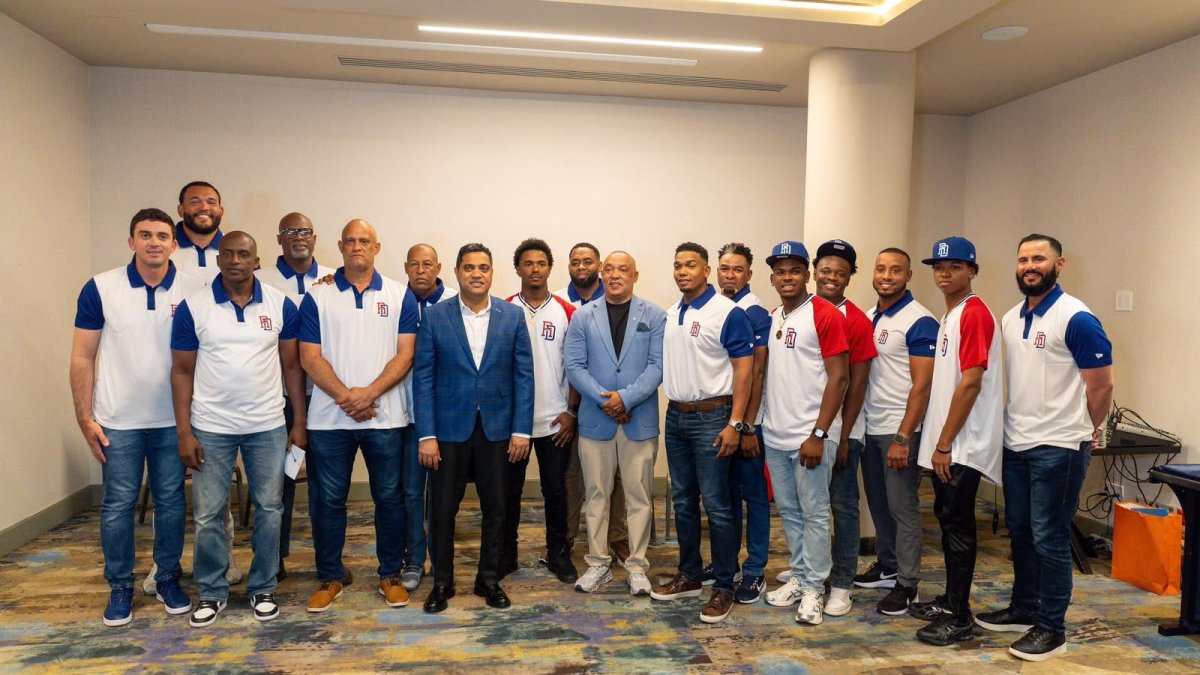 En el centro, el ministro Kelvin Cruz, acompañado por Mendy López (a la izquierda) y Juan Núñez (a la derecha), rodeado de algunos jugadores y coaches que estará en el equipo.