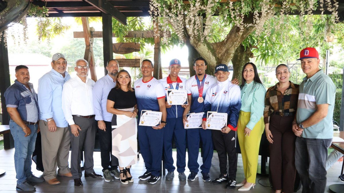 Desde la izquierda, Carlos Santos, de UDEPE, Ariel Vásquez, director Deportes, José Bautista, representando a su hermano Andrés Bautista, Patricia Muñoz, gobernadora; José Bueno, entrenador femenino softbol, Luis Hiciano, medallista de oro en softbol masculino, Luigy López, ganador de bronce en balonmano, Vladimir Frías, selección femenina baloncesto plata, Belkis Candelier, vicealcaldesa, Idelkys Félix, regidora de Moca y Robin Lantigua, regidor San Víctor.