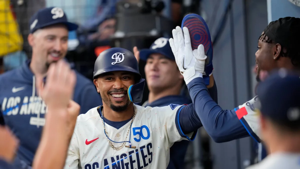 Mookie Betts, de los Dodgers de Los Ángeles, recibe felicitaciones de sus compañeros tras anotar una carrera.
