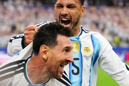 Leandro Paredes (5) agarra de la camiseta a su compañero Lionel Messi al celebrar el segundo gol de Argentina en la victoria 2-0 ante Austria en el Grupo J del Mundial, el lunes 22 de junio de 2026, en Arlington, Texas. (AP Foto/Julio Cortez)