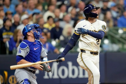 Brice Turang, segunda base de los Cerveceros, y el receptor de los Dodgers, Will Smith observan la bola irse de jonrón en la cuarta entrada del primer partido de la Serie de Campeonato.