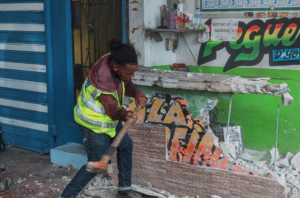 Un trabajador de la alcaldía empuja un banco en la acera de la calle Albert Thomas.