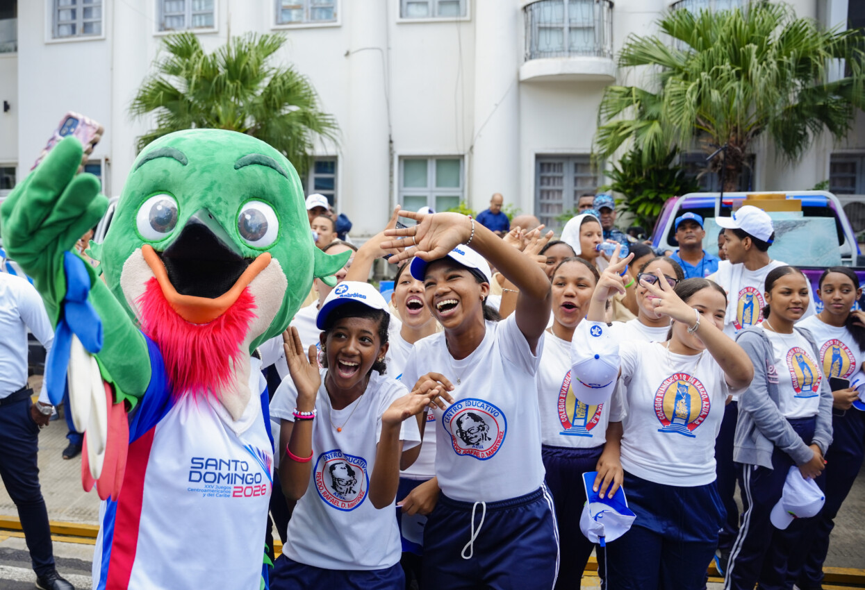 Las estudiantes del Centro Educativo Reverendo Rafael D. Martínez mientras comparten con la mascota de los Juegos 2026, Colí.