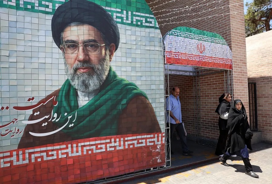 Iraníes pasan junto a una imagen del líder supremo iraní, el ayatolá Mojtaba Jamenei, en una calle de Teherán.