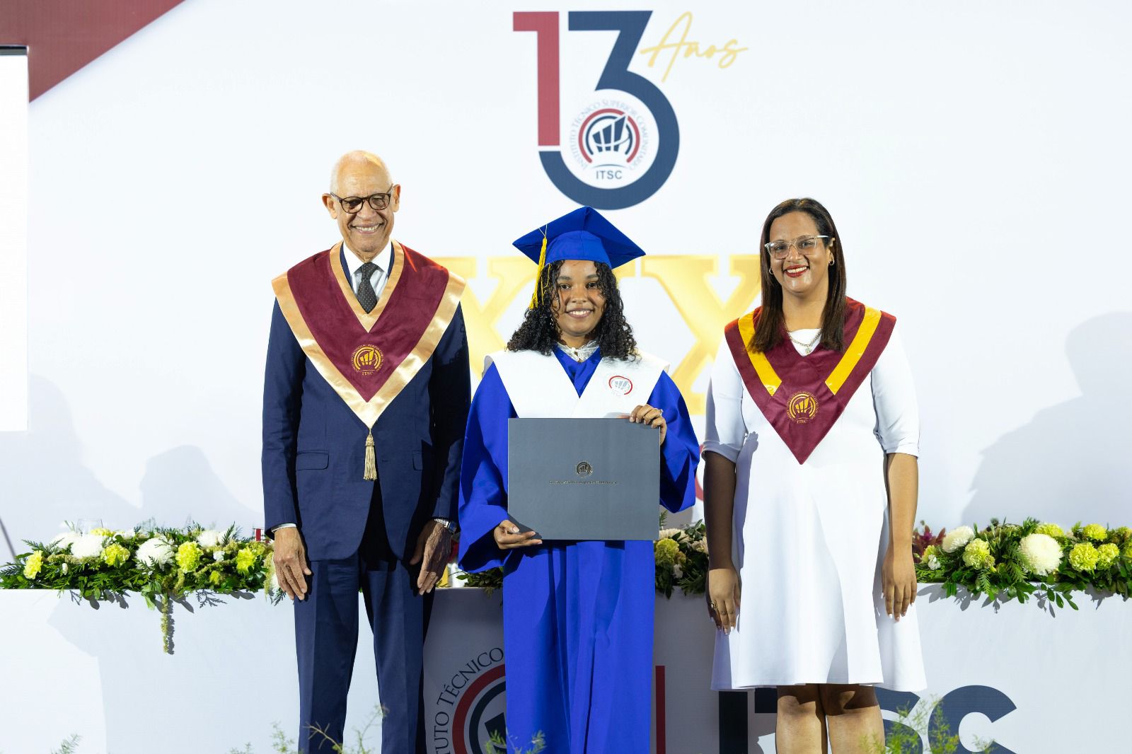 osé Ramón Holguín Brito, rector del ITSC, entrega el título a la graduanda Elizabeth Rafaela Germán Robles junto a la coordinadora del área de Salud de la institución.