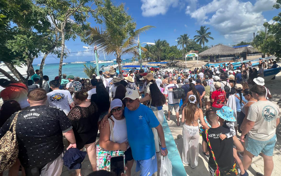 Cientos de personas esperan a que los asistentes de los barcos pongan ropa de salvamento para los turistas que abordan barcos en Bayahibe para realizar excursiones y otras actividades en la Isla Sauna. Jorge González
