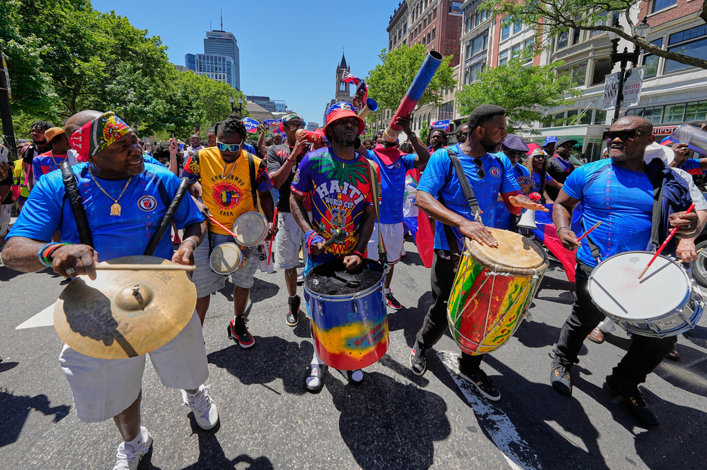 Los partidarios haitianos marchan por una calle en el centro de Boston, Massachusetts, antes del partido de fútbol del Grupo C de la Copa Mundial entre Haití y Escocia, el sábado 13 de junio de 2026, en Foxborough. (Foto AP/Martin Meissner)