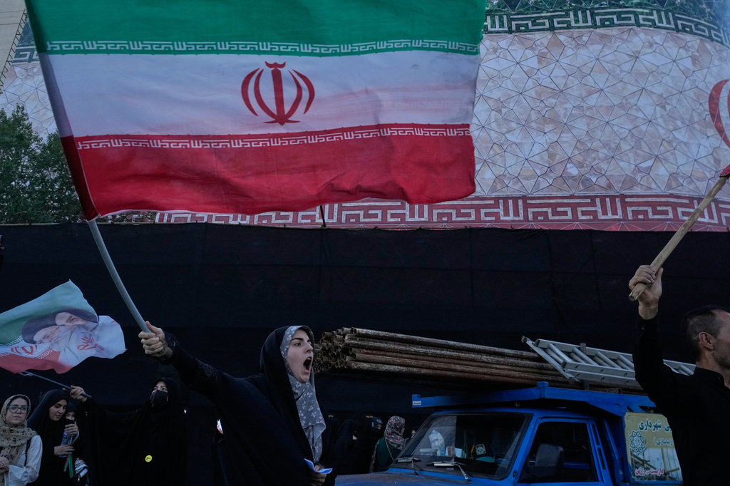 Una mujer ondea una bandera iraní y canta contra Irán y las conversaciones entre Estados Unidos e Irán en la Plaza de la Revolución Islámica en Teherán, Irán. (Foto AP/Vahid Salemi)