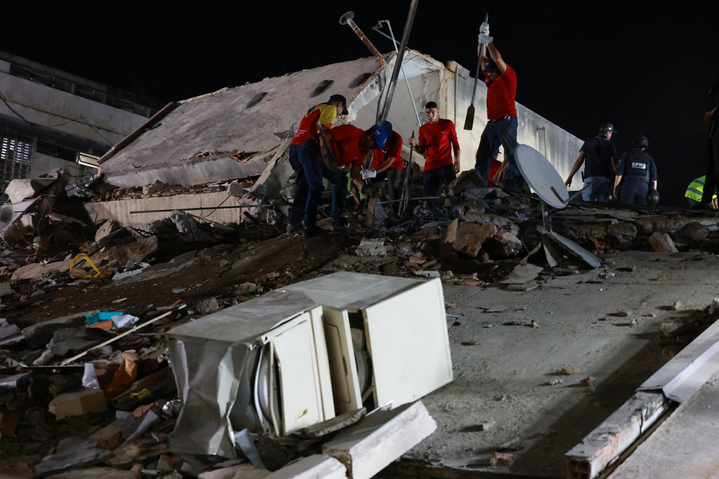 Los rescatistas buscan entre los escombros de un edificio derrumbado después de un terremoto en Caracas, Venezuela.