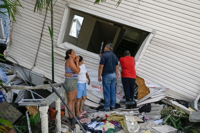 Familiares esperan entre los escombros