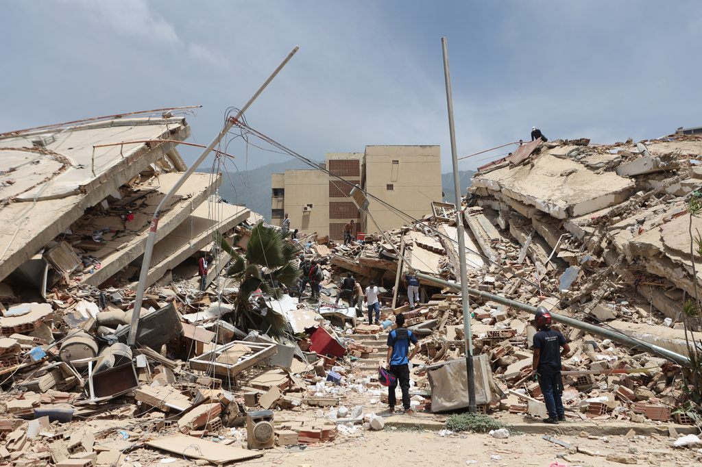 Residentes buscan entre los escombros de viviendas dañadas por un terremoto y varias réplicas que sacudieron La Guaira, Venezuela, el jueves 25 de junio de 2026. (AP).