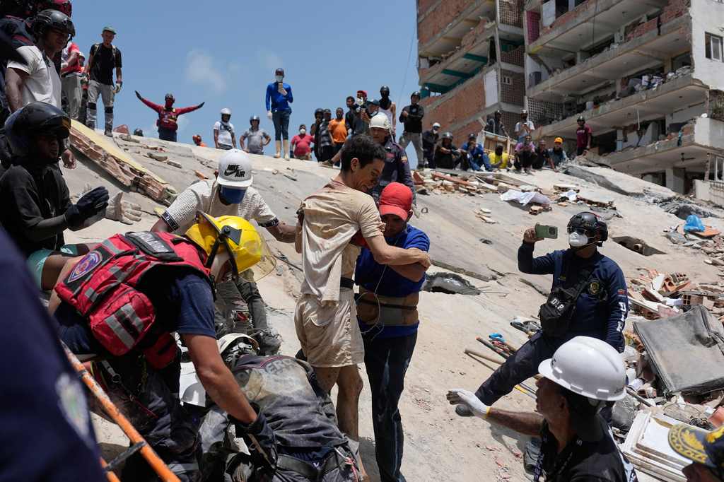 Los rescatistas ayudan a Daniel Cordero a excavar entre los escombros dos días después de que un terremoto sacudiera Catia La Mar, Venezuela.