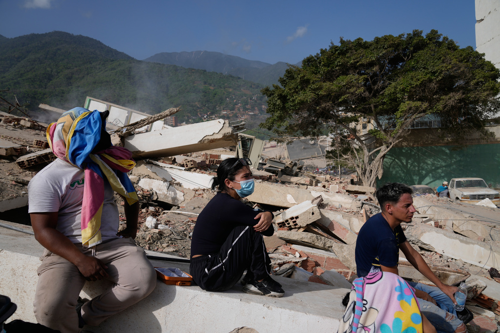 Los residentes se sientan cerca de sus casas destruidas dos días después de que un terremoto sacudiera La Guaira, Venezuela, el viernes 26 de junio de 2026. (foto)