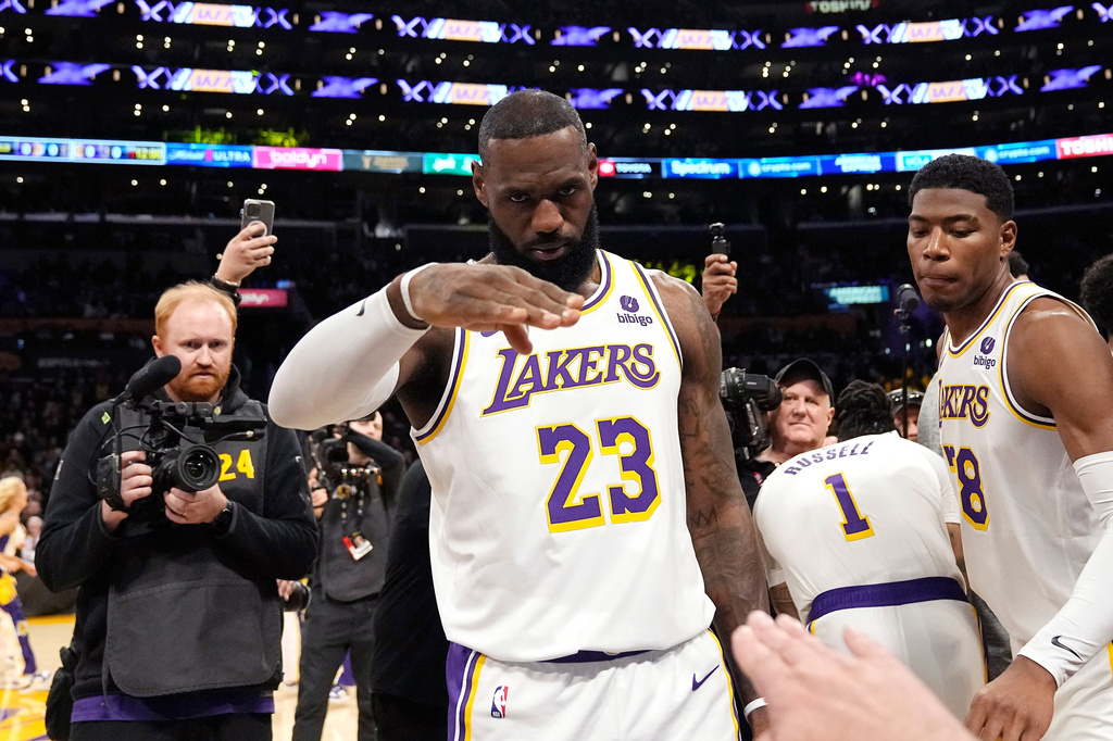 ARCHIVO - En esta fotografía del 2 de marzo de 2024, el delantero de Los Angeles Lakers, LeBron Hames, saluda al locutor Lawrence Tanter antes de un partido contra los Denver Nuggets. (Foto AP/Mark J. Terrill, Archivo)
