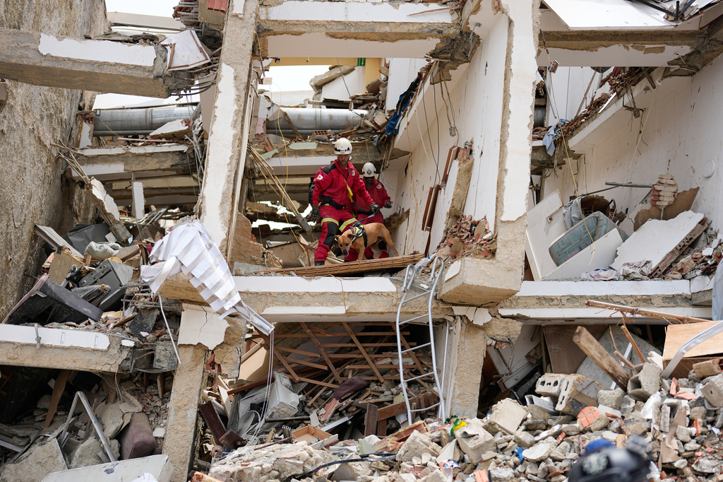 Los equipos de rescate españoles buscan entre los escombros de un edificio que se derrumbó durante el terremoto en La Guerra, Venezuela.