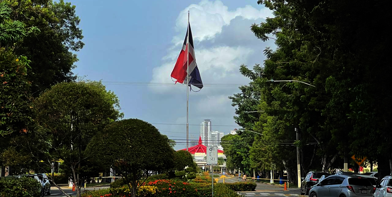 Rota y deshilachada esta Bandera Nacional ondea en la calle Paulo III en la Universidad Autónoma de Santo Domingo, teniendo como fondo el aula magna. Jorge González