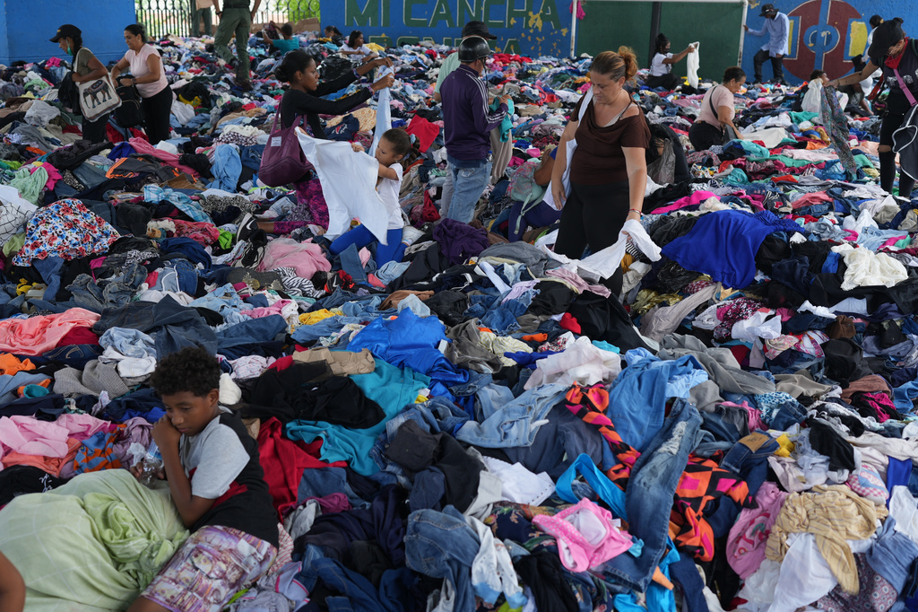 La gente elige ropa donada para las víctimas del terremoto en un complejo deportivo, el sábado 4 de julio de 2026, en La Guaira, Venezuela. (Foto AP/Arianna Cubillos)