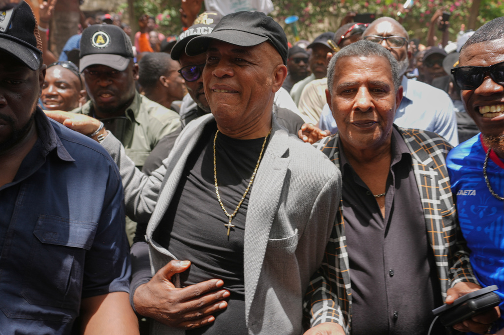 El expresidente de Haití Michel Martelly, al centro, rodeado de simpatizantes que le dieron la bienvenida, el miércoles 15 de julio de 2026, en Puerto Príncipe, Haití. (AP Foto/Odelyn Joseph)