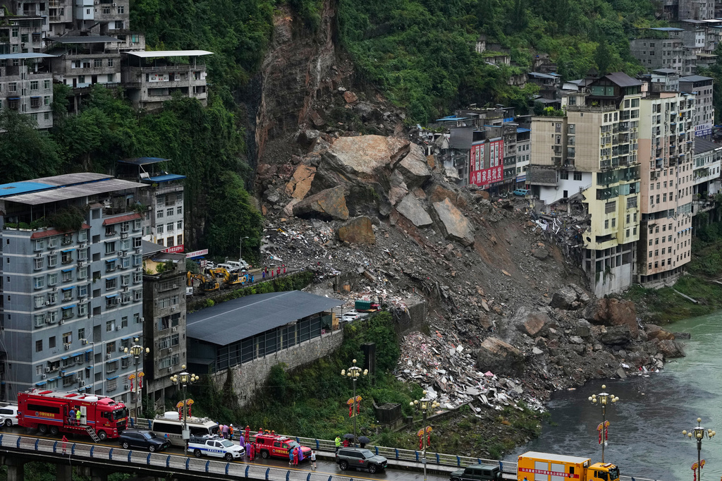 Rescatistas esperan en un puente mientras se preparan para llevar a cabo una operación de búsqueda y rescate en el lugar donde se produjo un deslave, en el condado de Pengshui, en la provincia suroccidental de Chongqing, Chija, el 18 de julio de 2026. (AP Foto/Andy Wong)