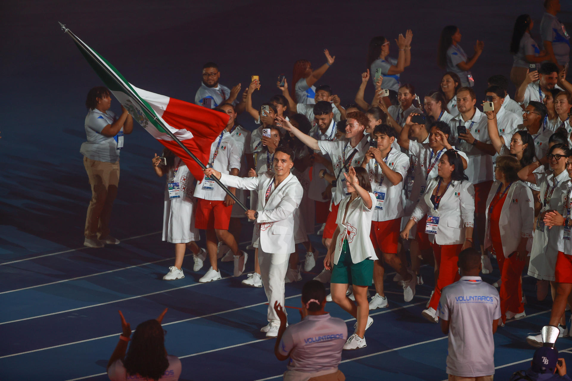 El abanderado de México, el buzo Juan Manuel Celaya y la esgrimista Gabriela Rodríguez, desfilan con la delegación durante la ceremonia inaugural de los XXV Juegos Centroamericanos y del Caribe Santo Domingo 2026 en el Estadio Félix Sánchez de Santo Domingo (República Dominicana). EFE/ Orlando Baría