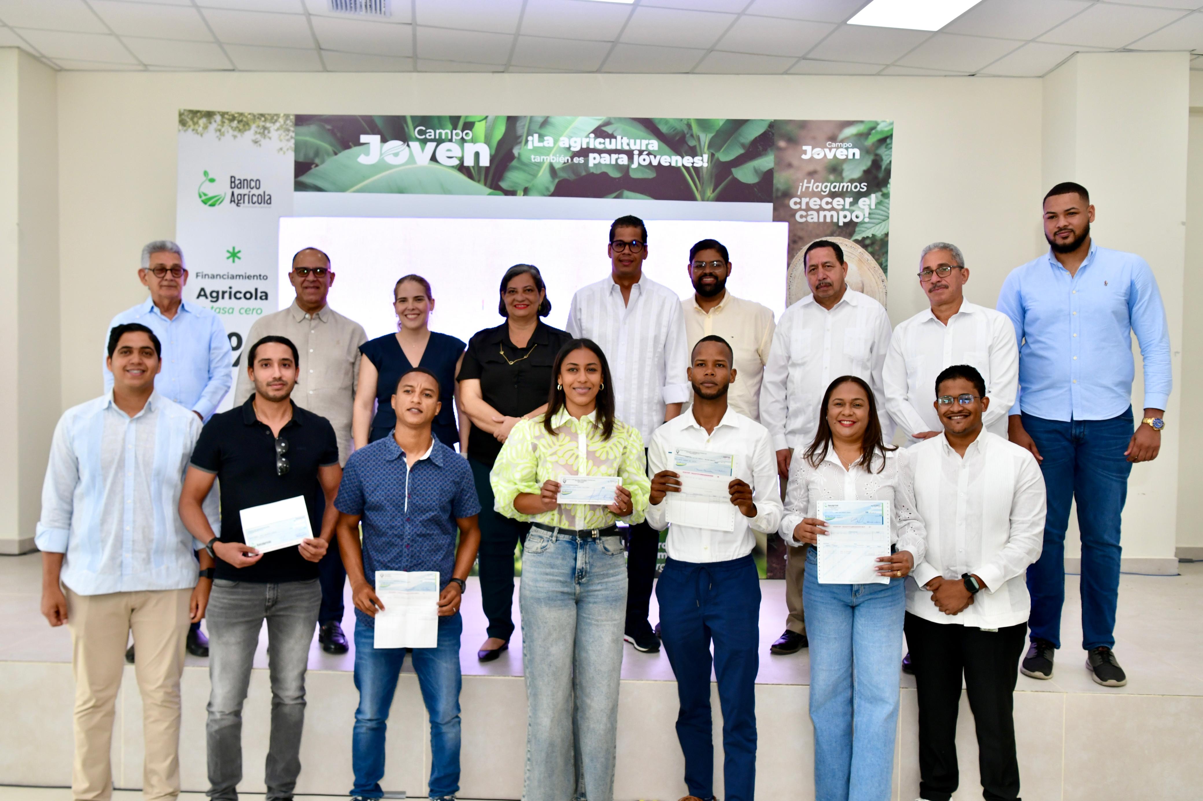 Los jóvenes beneficiados con los préstamos junto a los funcionarios asistentes al acto