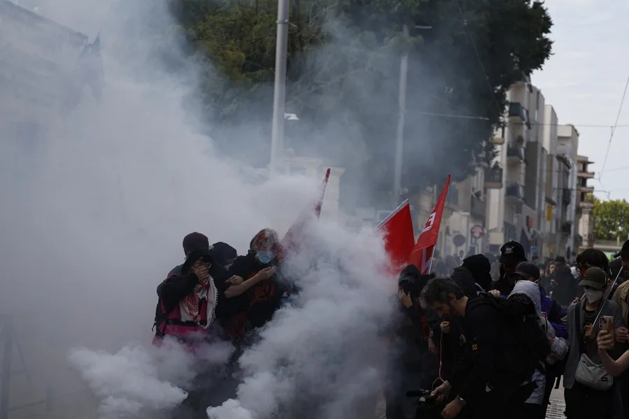 Estudiantes de secundaria permanecen en medio de gases lacrimógenos mientras estallan enfrentamientos entre alumnos y la policía antidisturbios