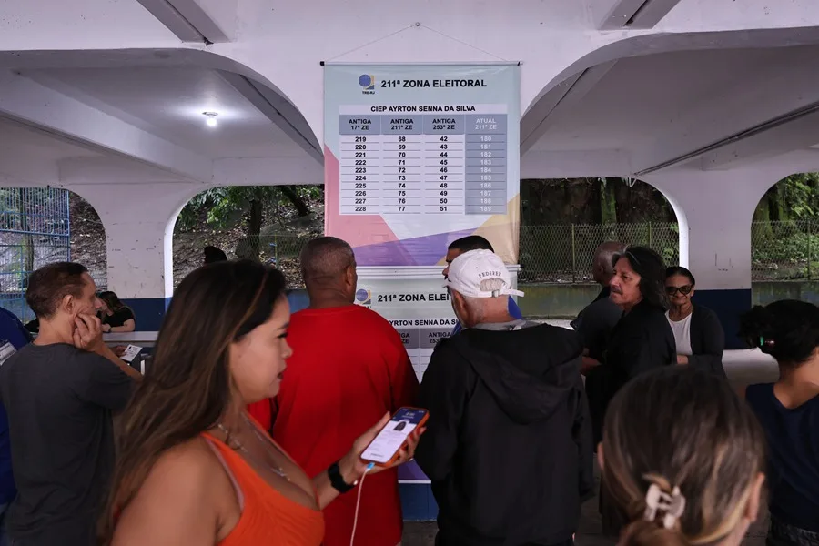 Ciudadanos verifican su nombre en el centro de votación instalado en la escuela Ayrton Senna da Silva, junto a la favela de Rocinha.