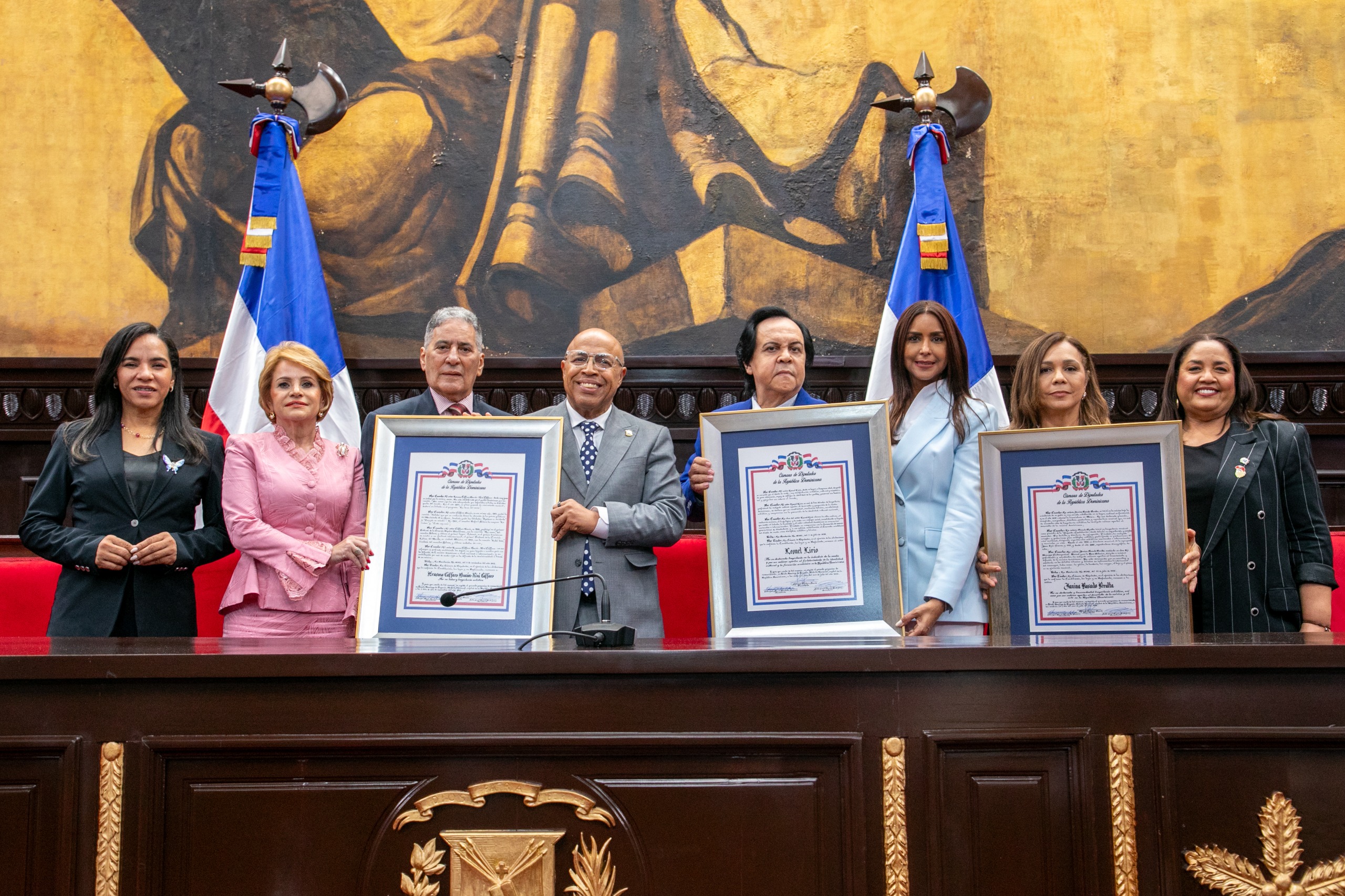 El presidente de la Cámara de Diputados, Alfredo Pacheco, entrega los reconocimientos a Niní Cáfaro, Leonel Lirio y Janina Rosado por sus aportes al arte, la cultura y la moda dominicana.