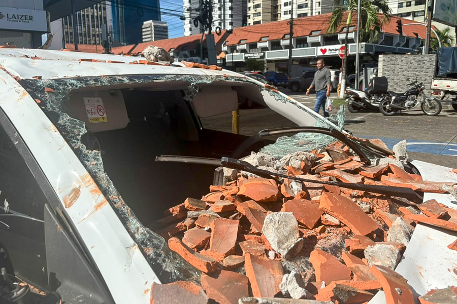 Fotografía de un vehículo afectado por restos de un edificio tras el terremoto