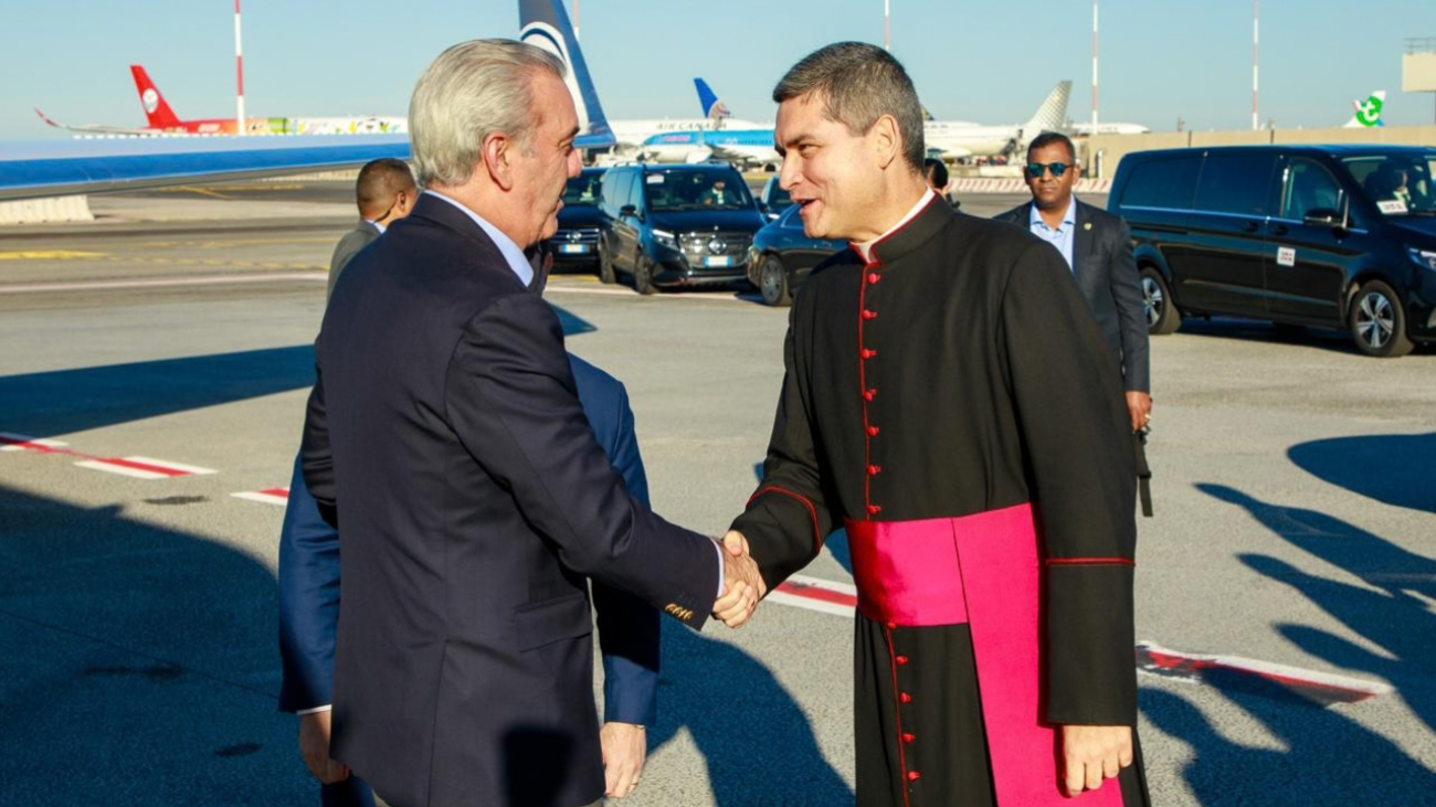 El presidente de la República, Luis Abinader, saludando al jefe de protocolo de la Santa Sede, monseñor Javier Domínguez Fernández, a su llegada en Roma, Italia.
