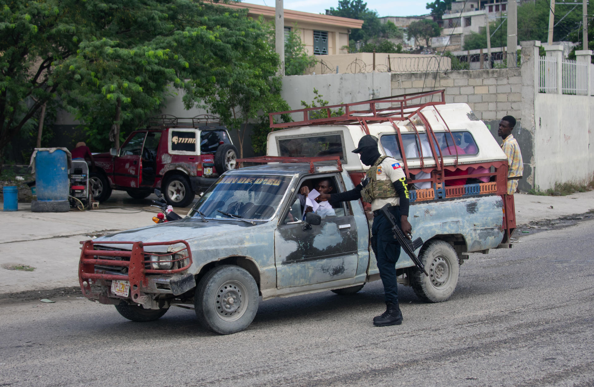 PUERTO PRÍNCIPE (HAITÍ).- Un policía haitiano revisa los documentos de un conductor este sábado, mientras continúa la búsqueda de cuatro militares salvadoreños integrantes de la Fuerza de Supresión de Pandillas (GSF, sigla en inglés) desaparecidos tras sufrir una emboscada, en Puerto Príncipe (Haití). EFE/ Jonet St. Élois